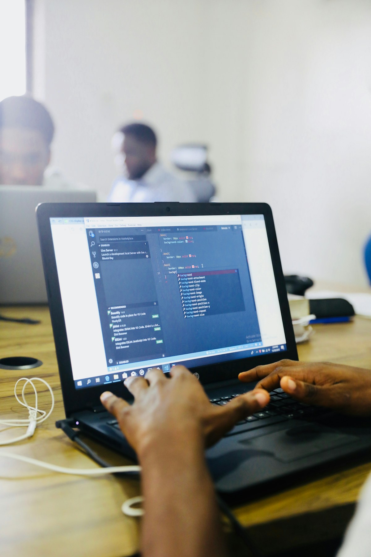 Black developer hands working with code on a laptop